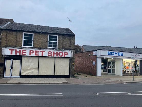 A photo of the signs on two shops with "The Pet Shop" sitting directly next to a "Boyes" store. It's on Station Road in the Cambridgeshire town of March, England,